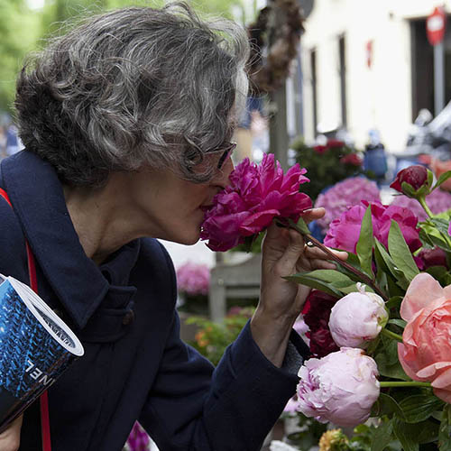 Público en un puesto con flores en el Mercado de las Flores de Vogue en la calle Jorge Juan