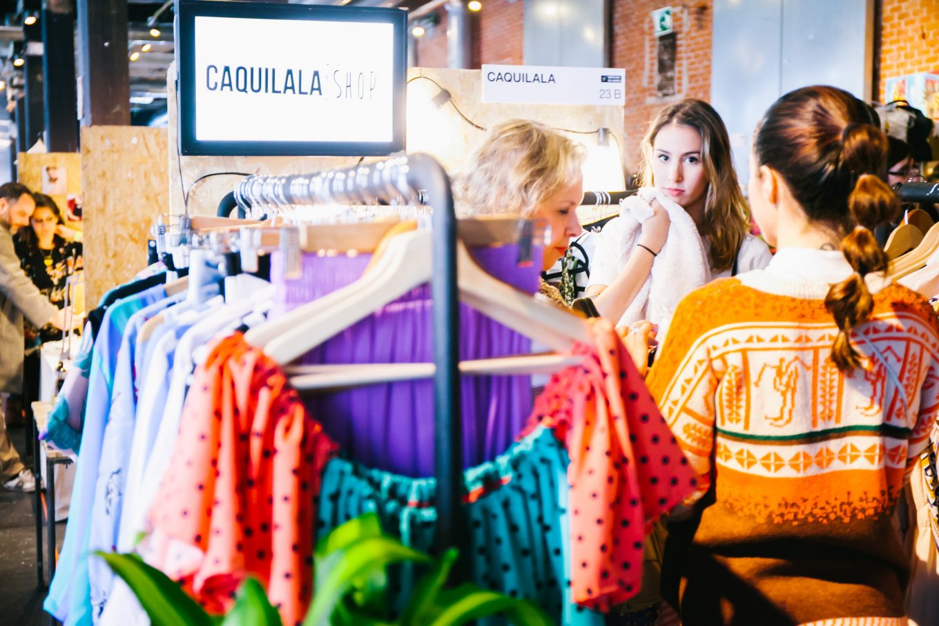 Mujeres seleccionando ropa en puesto de mercado