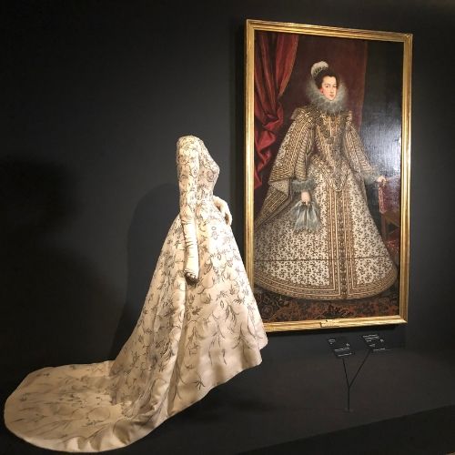 Maniquí en exposición con cuadro detrás