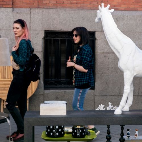 Mujeres contemplando puestos arte callejero