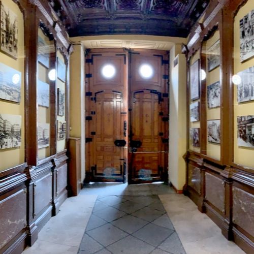 Pasillo con puerta a la calle con fotos antiguas colgadas de las paredes