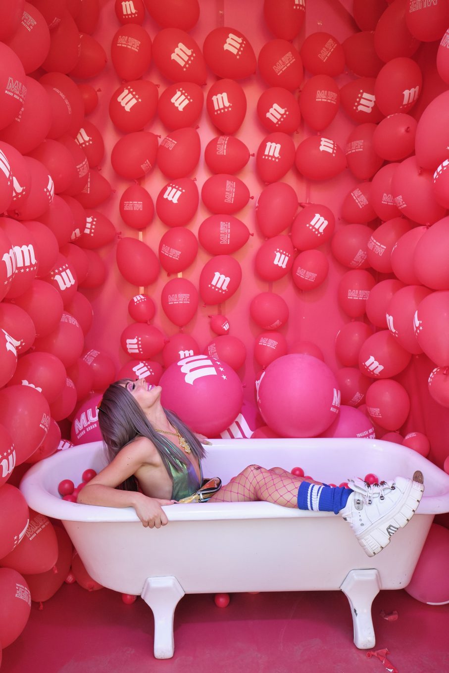 Modelo dentro de bañera con globos en las paredes
