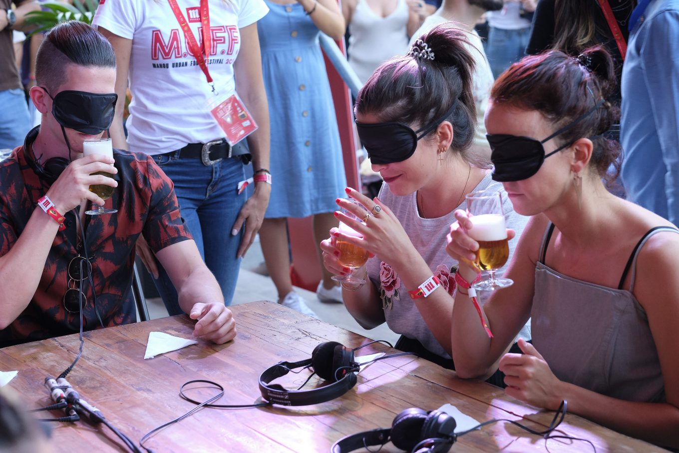 Dos mujeres y un hombre realizando una cata ciega de cerveza