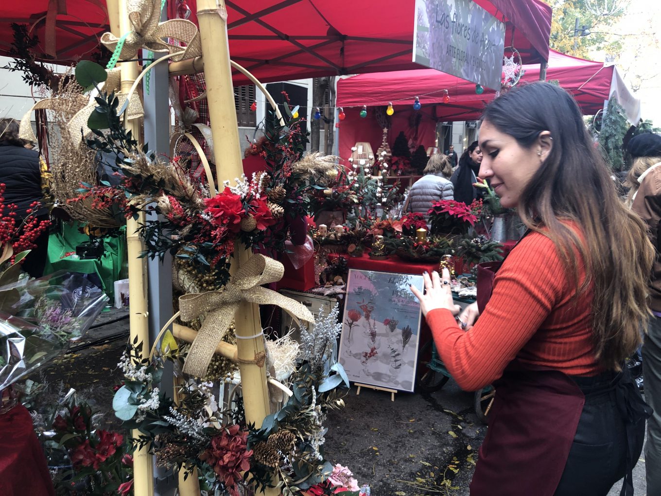 Mujer observando arreglos florales navideños