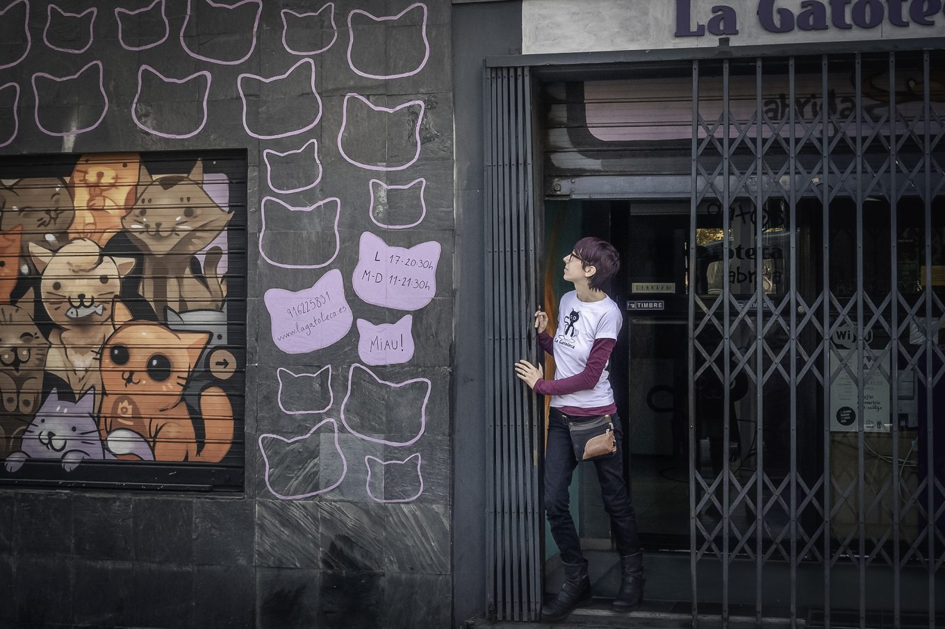 Mujer retirando verja de puerta de local