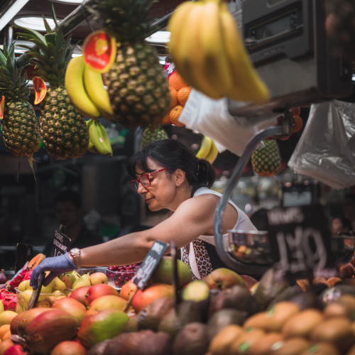 Mujer atendiendo en puesto de frutas