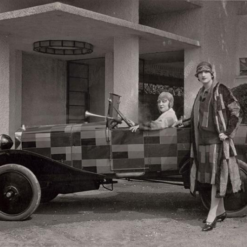 Mujeres posando con coche, una de ellas, conduciendolo