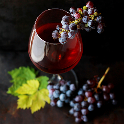 Vaso de vino con uvas dentro