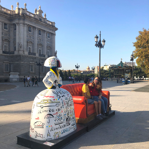 Menina con sofá y personas sentadas en él en Plaza de Oriente, Madrid