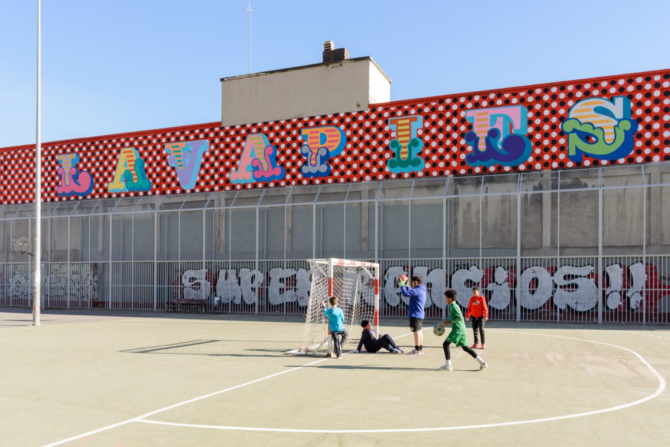 Letras artísticas Lavapiés en canchas deportivas urbanas con grupo de chicos jugando