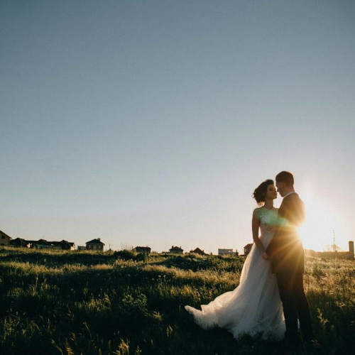 Pareja de recien casados en campo al atardecer