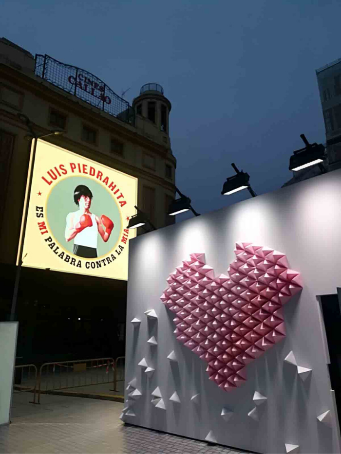 Mural con corazón en relieve con cartel de monologuista detrás