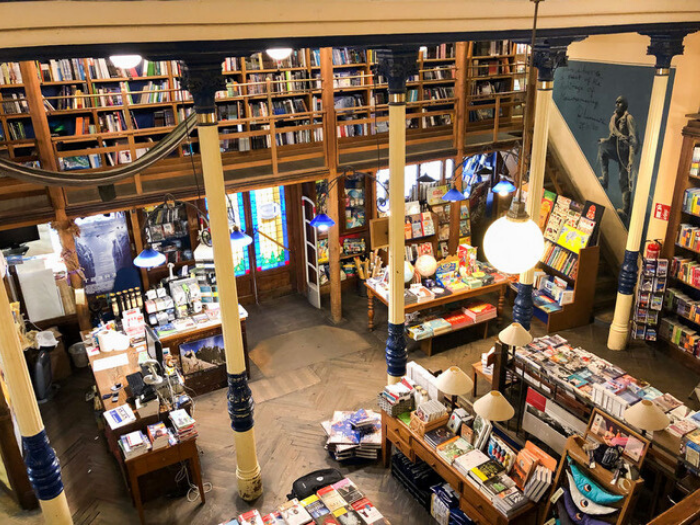 Interior de librería con estanterías y expositor a dos niveles