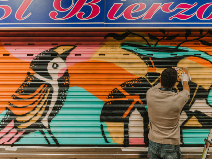 El artista Inventura Studio pinta un cierre de un puesto del mercado de Los Mostenses