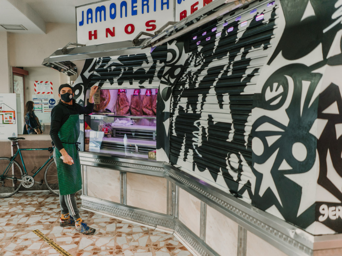El artista Mercado pinta un cierre de un puesto del mercado de Los Mostenses