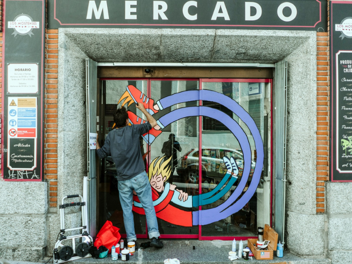 El artista Sopas con Hondas pinta la puerta del mercado de los Mostenses
