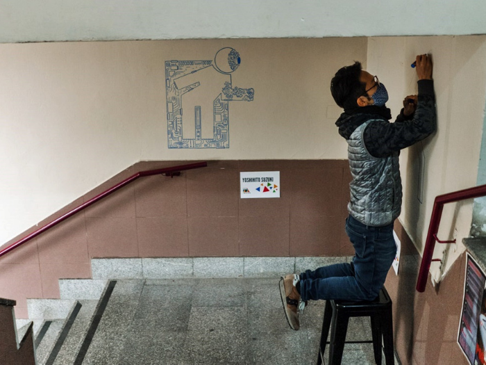 El artista Yoshihito Suzuki pinta una pared del mercado de Los Mostenses