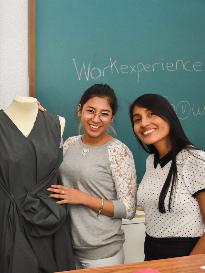 Alumnas de costura junto a un maniquí