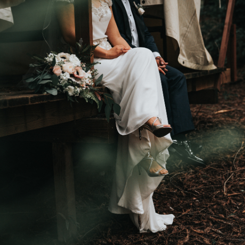 Vestido de novia, ramo de flores y zapatos de tacón plateados