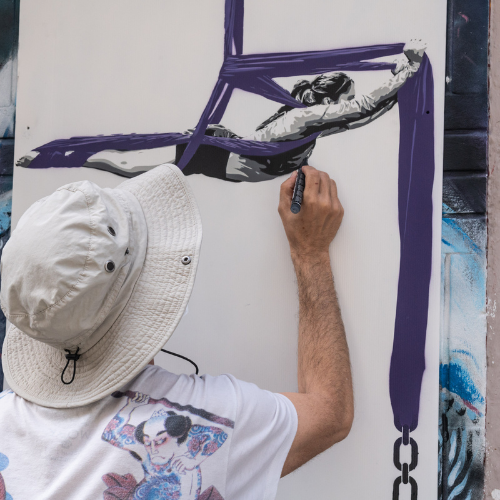 Artista callejero pintando un mural