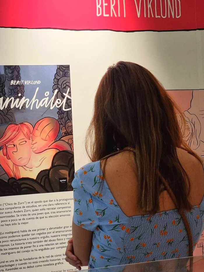 Una visitante observa los paneles de la exposición 'Aquí Llegan Ellas' en Centro Centro Cibeles