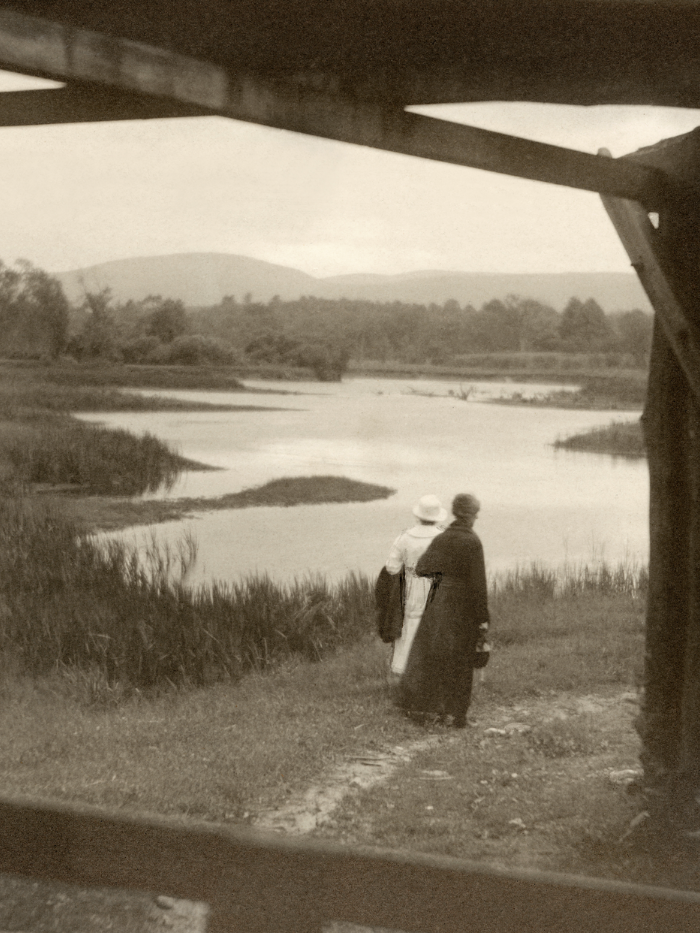 Dos mujeres pasean junto a un río. Fotografía de Margaret Watkins