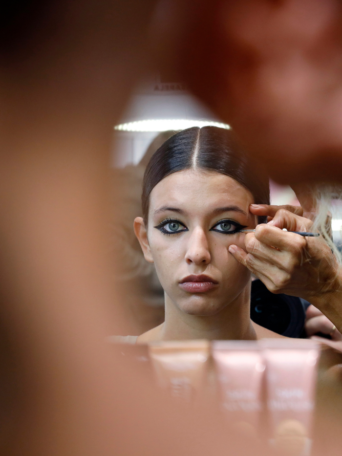 Una modelo mientras la maquillan en el backstage de Pertegaz