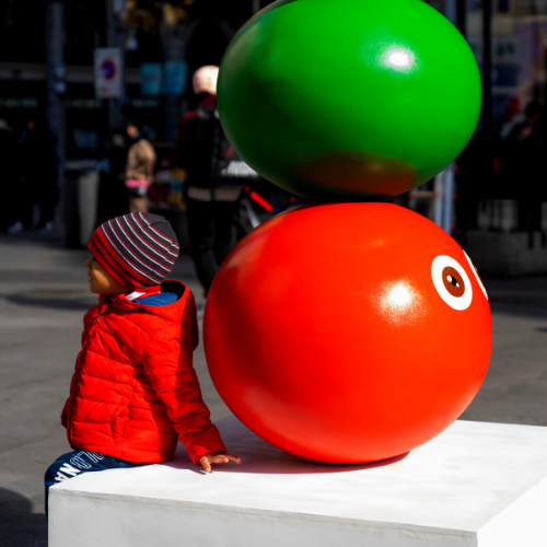 Niño junto a una estatua contemporánea en la calle Montera